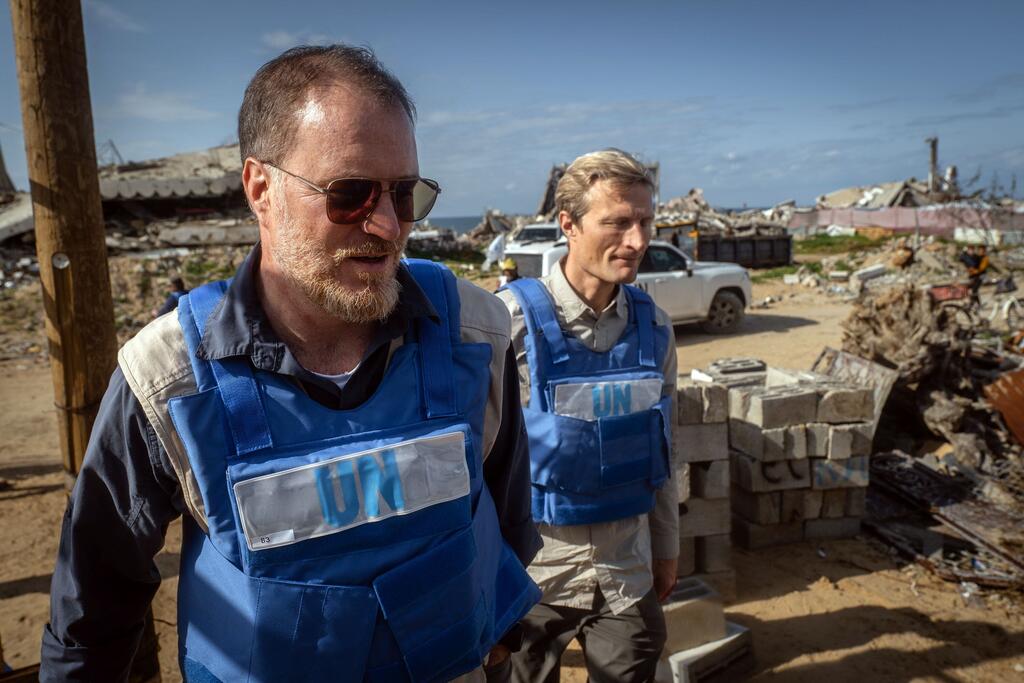 Shaun Hughes (left), WFP Country Director for Palestine, walks amid massive destruction in Gaza.